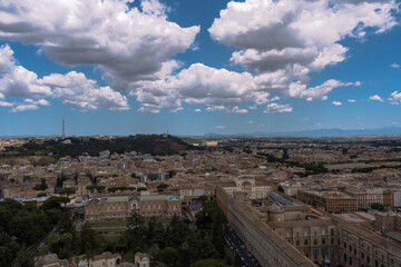 Obraz premium Sweeping vista of a European city under a vast blue sky, showcasing historic architecture and verdant hills in the distance.