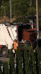 Śmieciarka pod altaną śmietnikową odbierająca śmieci © tomo81