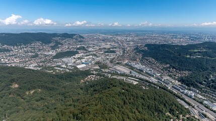 Fototapeta premium Aerial view of a sprawling city surrounded by mountains on a clear day showcasing urban development and natural landscapes in harmony