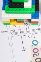 Small house made of toy blocks, electrical diagrams of house and polish currency money. Building...