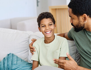 Portrait of a happy teenage boy son talking to his father at home. Sharing secrets and having fun,...