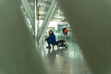 Woman sitting in the airport shuttle with her suitcases, waiting for her boarding time.