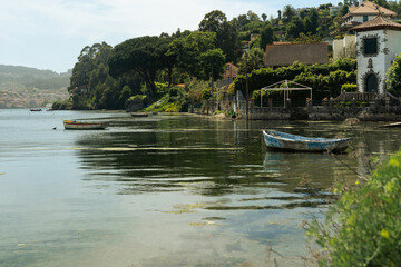 A couple of boats are moored in the Galician estuaries, in a very small village. The boats are old and faded, but the scene is beautiful.