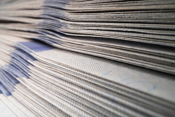 A close-up of a stack of 100 dollar banknotes.