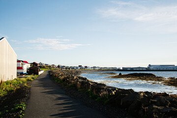Coastal pathway and scenic Icelandic village under a bright blue sky