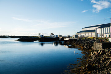 Fototapeta premium Harbor View with Building by the Waterfront in Iceland Under Clear Blue Sky