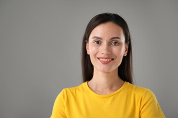 Fototapeta premium Portrait of beautiful woman on light grey background. Space for text