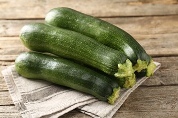 Fresh ripe zucchinis on wooden table, closeup