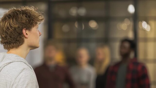 Medium shot of a focused product strategist analyzing user engagement graphs to guide rollout phases with blurred meeting participants behind.