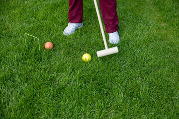 Woman plays polo on the green meadow, polo mallet, orange and yellow ball. Sport, fun, leisure activity, outdoors, summer, sports game.