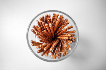 Glass Jar of Pretzel Sticks on White Background – Crisp Snack Still Life