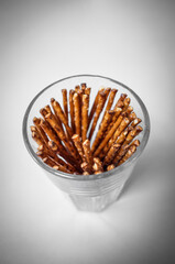 Glass Jar of Pretzel Sticks on White Background – Crisp Snack Still Life