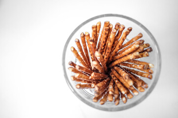 Glass Jar of Pretzel Sticks on White Background – Crisp Snack Still Life