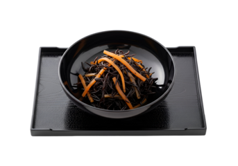 Dark bowl of black noodles with orange strips on a black tray, showcasing a simple yet elegant presentation.