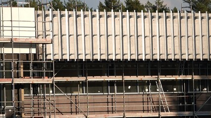 Budynek w budowie z widocznym rusztowaniem i elementami montażu © tomo81