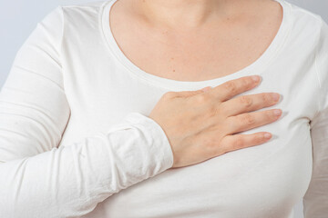 Female hands massage a painful chest with heart pain. Women's health, middle age.