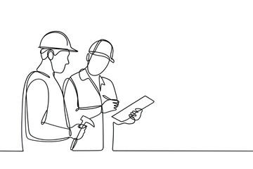 Two construction workers in hard hats discussing plans on a clipboard