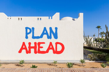 Plan ahead symbol. Concept word Plan ahead on beautiful white wall. Beautiful blue sky background....
