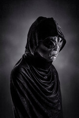 Mysterious humanoid alien at night over dark misty background
