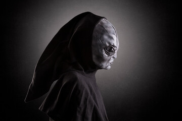 Mysterious humanoid alien at night over dark misty background