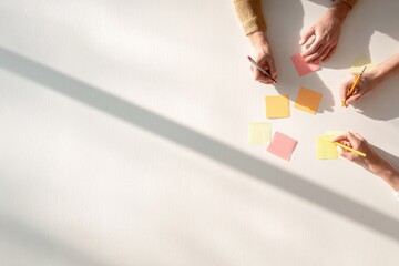 Obraz premium Hands engaged in brainstorming with colorful sticky notes on cle