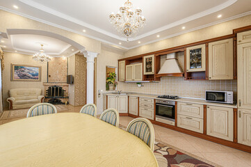 Elegant kitchen and living area with classic cabinets, chandelier, and a cozy fireplace
