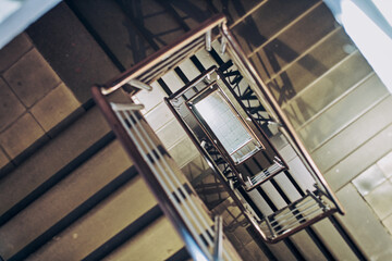 Intricate spiral staircase offers mesmerizing architectural view in Nizhny Novgorod. Captured from above, harsh lighting creates striking shadows, enhancing geometric patterns