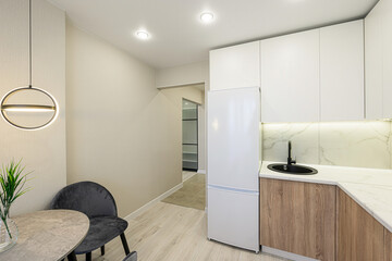 modern kitchen featuring white cabinets, wood-look lower cabinets, marble countertop, a black sink,...