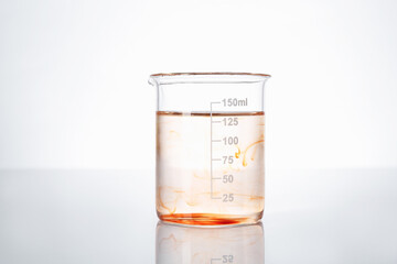 Glass beaker with dirty water on white background