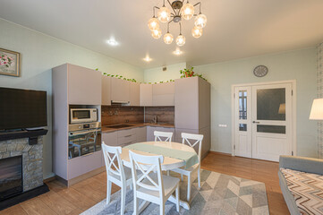 cozy kitchen and dining area with neutral tones, a round table, and modern fixtures
