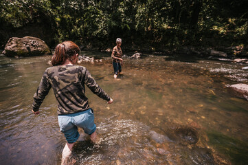 Naklejka premium Mother and daughter having fun and cooling off in the river on a hot summer day.
