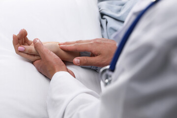 Obraz premium Doctor checking woman's pulse with fingers at home, closeup