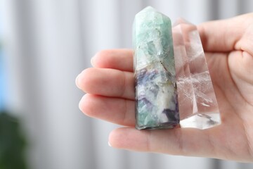 Woman with healing crystals on blurred background, closeup