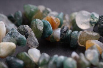 Many different healing stones on gray table, closeup