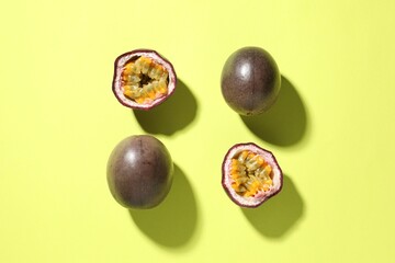 Fresh passion fruits on pale green background, flat lay