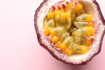 Half of fresh passion fruit on pink background, closeup. Space for text