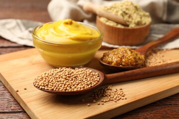 Different types of mustard on wooden table, closeup