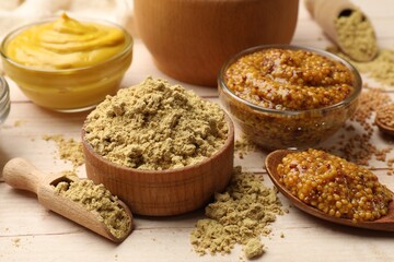 Different types of mustard on wooden table, closeup