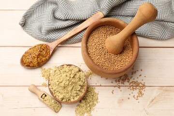 Different types of mustard on wooden table, flat lay