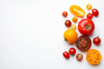 Different ripe tomatoes on white table, flat lay. Space for text