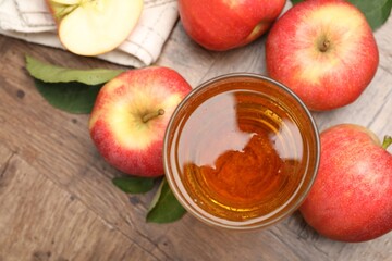 Fresh cider in glass and apples on wooden table, flat lay