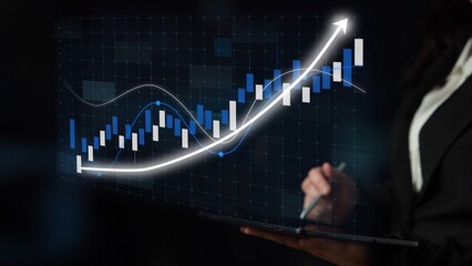 A businesswoman uses a tablet to analyze market growth trends through financial charts. This image captures a blend of technology and finance in a corporate setting. Copula