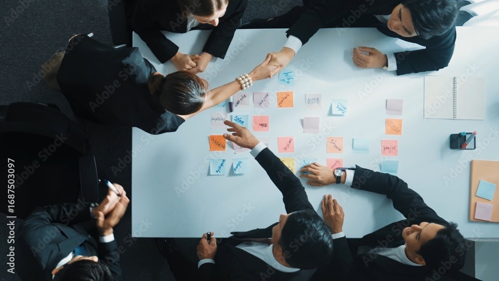 Aufkleber smart manager looking at board while making handshaking with investor while business group making de
