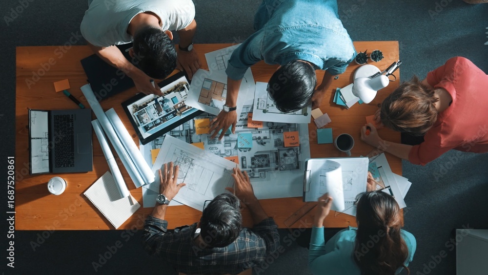 Poster top view of civil engineer team holding blueprint and standing at table with laptop, project plan an