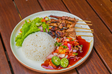 Delicious Indonesian satay with rice, salad, and vibrant condiments for a perfect meal