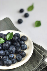 Blueberries are lying in a plate on the table