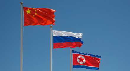 Three National Flags of China Russia and North Korea Against a Clear Blue Sky