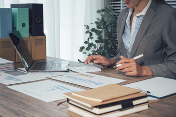 Collaborative business meeting featuring a team reviewing financial charts and a tablet device, Corporate analysis and reporting of data with a team approach to office technology