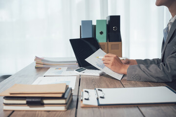 Administrative Workspace: An organized office scene, focusing on the meticulous detail of administrative work. A person is seen engaged in paperwork at a desk, surrounded by business documents.