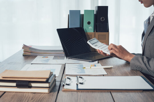 Collaborative business meeting featuring a team reviewing financial charts and a tablet device, Corporate analysis and reporting of data with a team approach to office technology